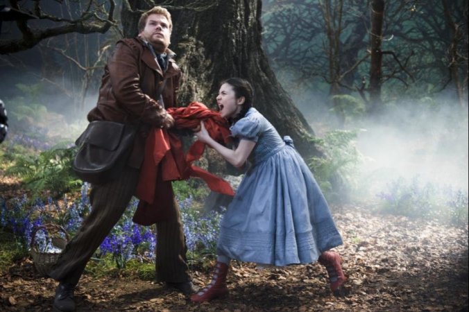 The Baker (James Corden) attempts to steak the Red Riding Hood from hers truly (Lilla Crawford). Her unbearable screaming doesn't make you root for her any more than you should. 